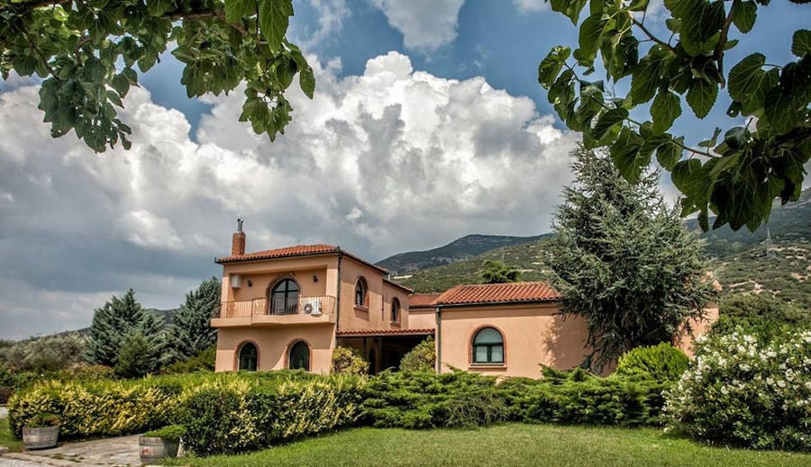 one side of the building with green lawn and trees of 'Dougos Winery'